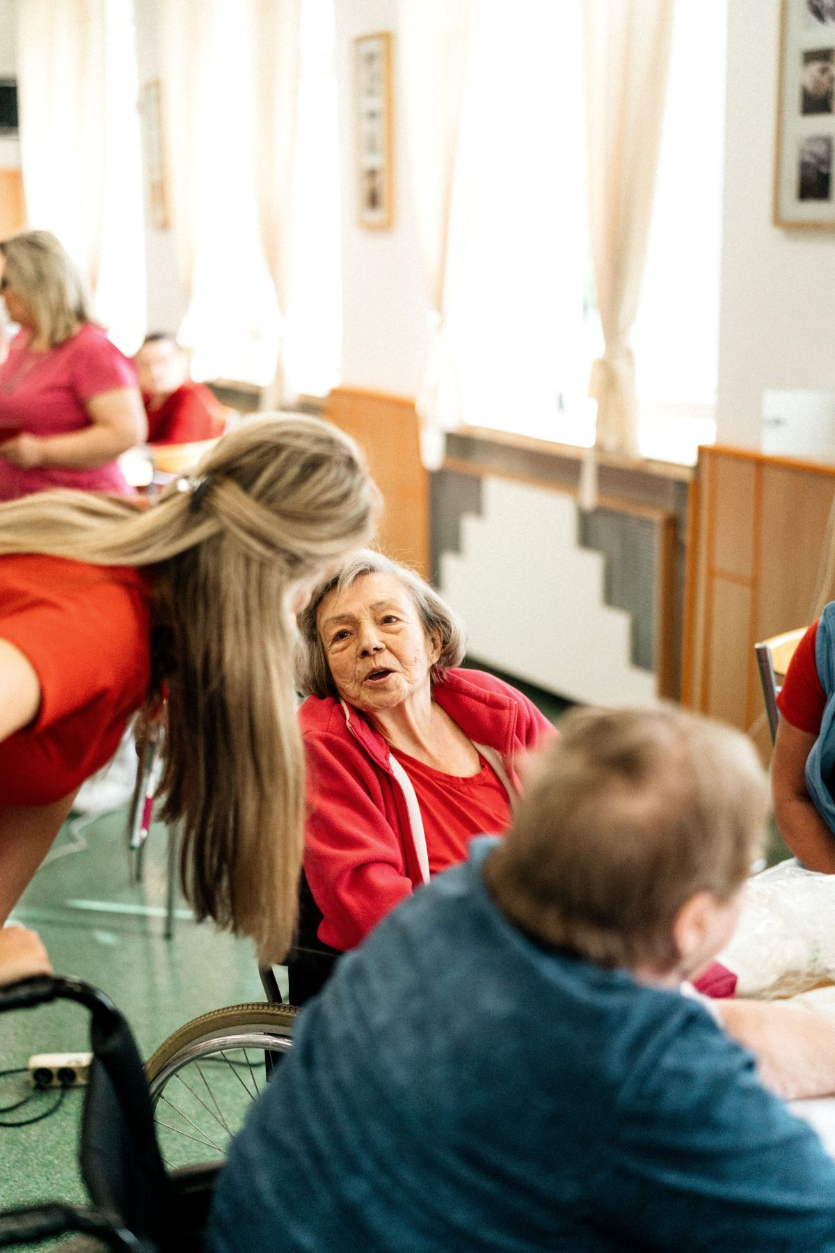 Care team chatting with a resident in a care home day room