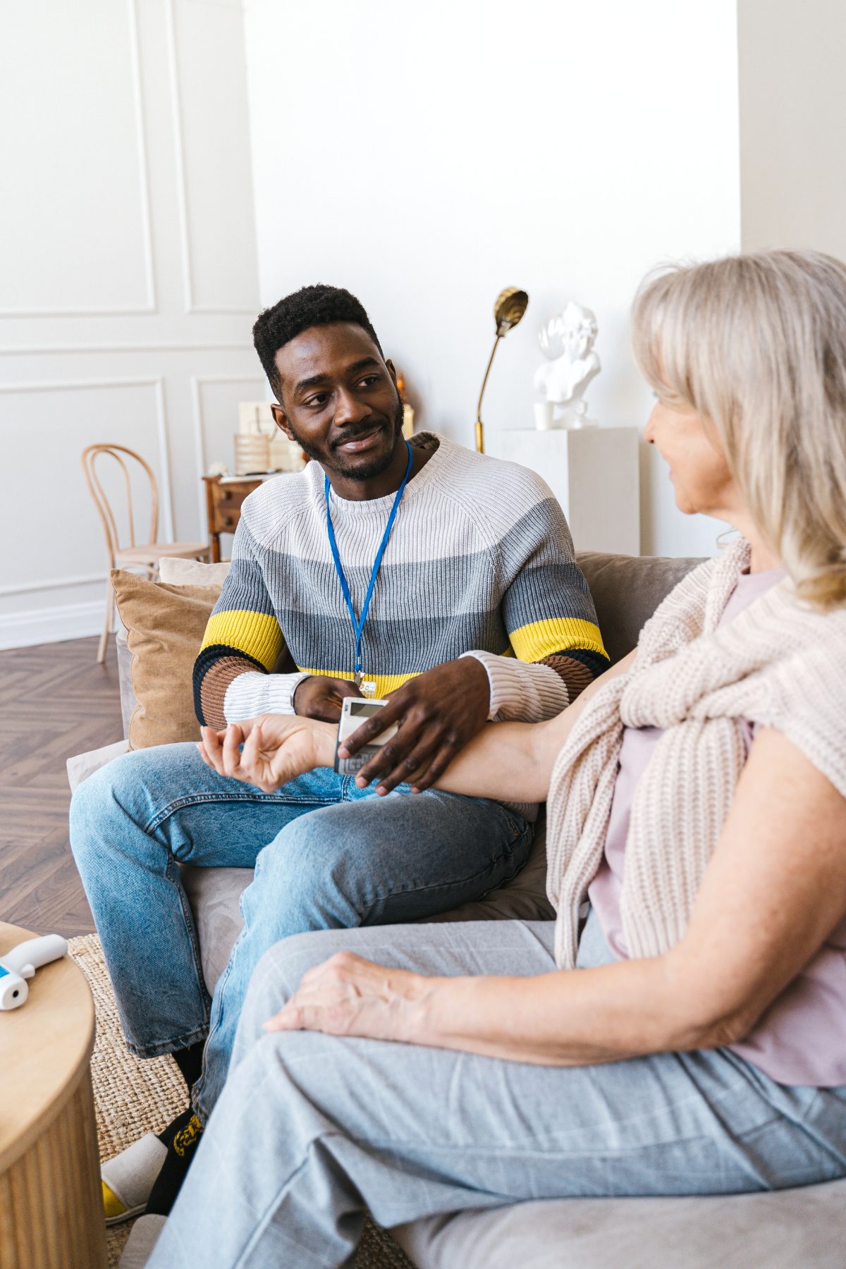 Care worker checking blood pressure with a client during a home care visit